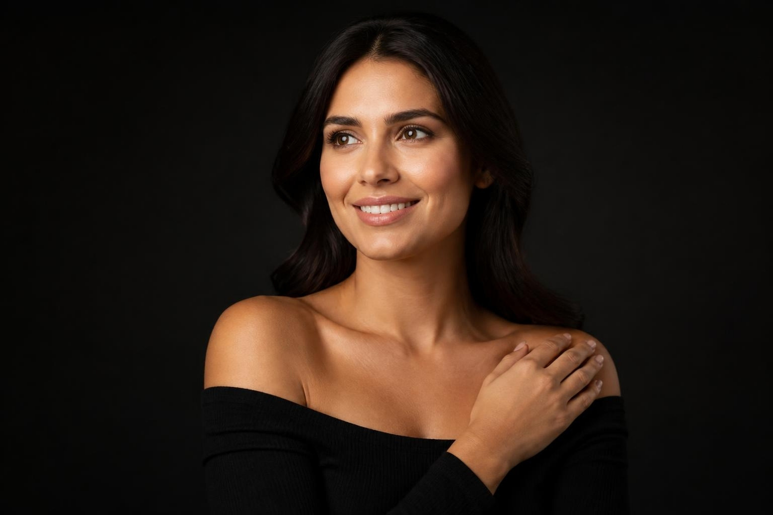 Mulher sorrindo com blusa preta de ombros à mostra